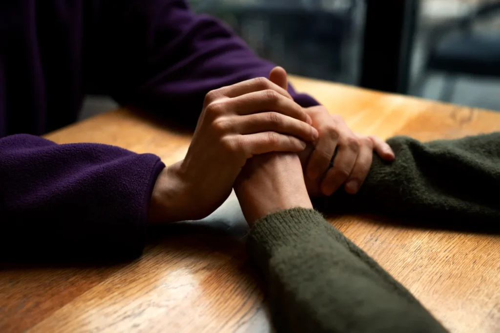 Manos entrelazadas en un gesto de apoyo terapéutico en el tratamiento especializado en TCA, salud mental relacionada | Fametsis Psicoterapeutas 